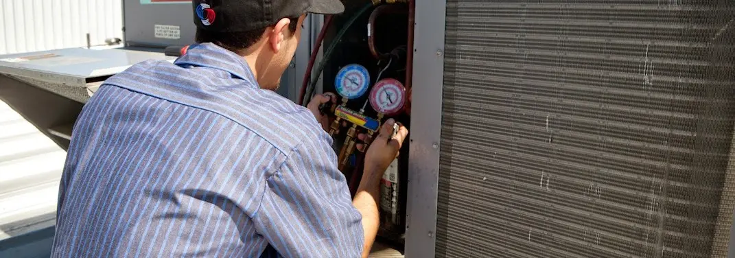 HVAC technician servicing a condenser unit in New Berlin
