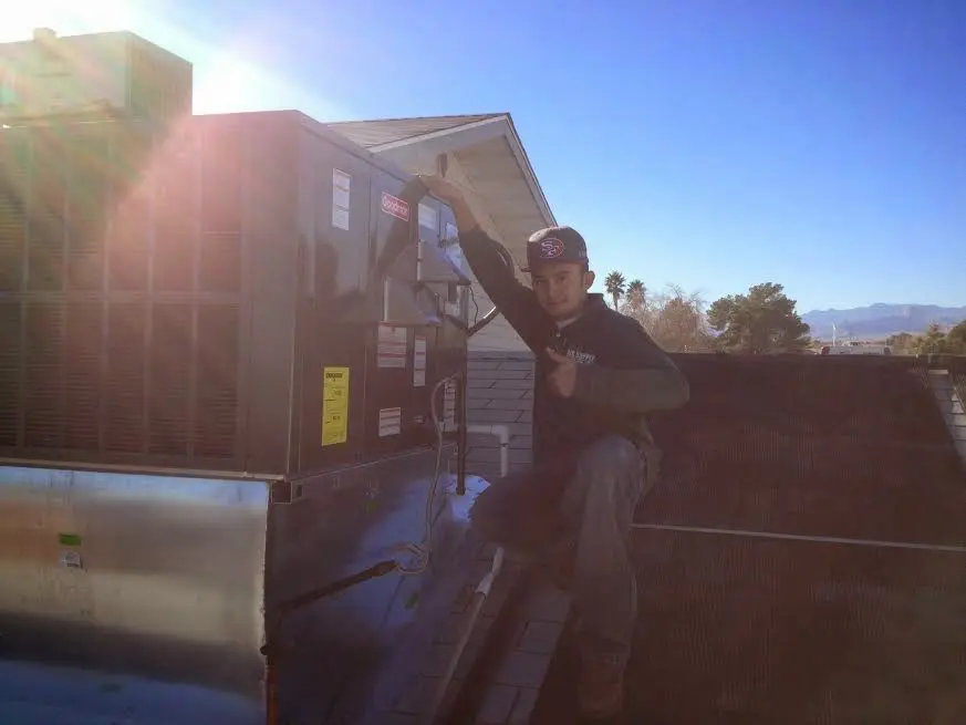 HVAC technician performing AC Tune-Up on a rooftop unit in New Berlin